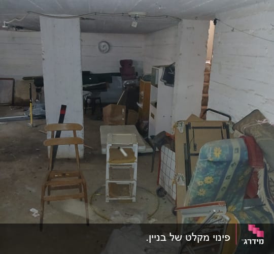 מרתף מבולגן עם כיסאות, קרטונים וכלי ניקוי